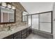 Elegant bathroom featuring dual sinks with vessel bowls, granite countertop, and a glass-enclosed shower at 12646 S Dove Creek Way, Parker, CO 80134