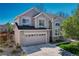 Beautiful two-story home with stone accents, a well-manicured lawn, and a two-car garage at 12646 S Dove Creek Way, Parker, CO 80134