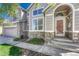Inviting front entrance featuring a glass door, stone accents, manicured landscaping and a two-car garage at 12646 S Dove Creek Way, Parker, CO 80134