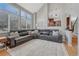 Open living room with tall windows, a comfortable leather sofa, and an open view to the kitchen, perfect for relaxation at 12646 S Dove Creek Way, Parker, CO 80134