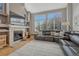 Inviting living room with a cozy fireplace, large windows, and plush seating, creating an ideal spot for relaxation and entertainment at 12646 S Dove Creek Way, Parker, CO 80134