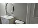 Updated bathroom with stylish vanity and modern round mirror at 5956 S Winnipeg St, Aurora, CO 80015