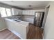 Modern kitchen features stainless steel appliances, white cabinets, and ample counter space at 5956 S Winnipeg St, Aurora, CO 80015