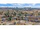 An elevated view of a tree-lined neighborhood, showcasing an urban skyline and well-kept front yards at 8690 E Chenango Ave, Denver, CO 80237