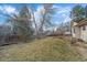 Green backyard with sparse trees and a wooden fence at 8690 E Chenango Ave, Denver, CO 80237