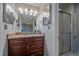 Bathroom with granite countertop vanity, mirrored cabinets and a shower with glass doors at 8690 E Chenango Ave, Denver, CO 80237