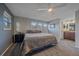 Bedroom features soft carpet, a ceiling fan, and an ensuite bathroom with granite counters at 8690 E Chenango Ave, Denver, CO 80237