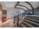 Bright dining area with vaulted ceilings, exposed beams, and modern light fixture, and carpeted upper level at 8690 E Chenango Ave, Denver, CO 80237