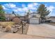 Home with a front yard featuring mature landscaping and a long driveway leading to an attached garage at 8690 E Chenango Ave, Denver, CO 80237