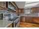 Gourmet kitchen with stainless steel appliances, stone countertops, and tile backsplash at 8690 E Chenango Ave, Denver, CO 80237
