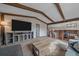 Open living room featuring exposed beams and view into the kitchen area at 8690 E Chenango Ave, Denver, CO 80237
