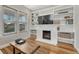 Living room featuring hardwood floors, built-in shelving, fireplace, and a large window at 1920 S Downing St, Denver, CO 80210
