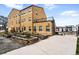 Exterior view of a yellow apartment building showcasing a garden area with planter boxes and a nearby playground at 2835 W Parkside Pl # 305, Denver, CO 80221