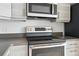 Updated kitchen featuring gray cabinets, gray countertops, stainless steel range, and stainless steel microwave at 2835 W Parkside Pl # 305, Denver, CO 80221