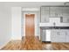 Galley kitchen featuring modern gray cabinets, stainless steel appliances, and hardwood floors that transition into the living area at 2835 W Parkside Pl # 305, Denver, CO 80221
