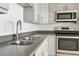 Kitchen area featuring stainless steel sink, gray cabinets, gray countertops, and stainless steel appliances at 2835 W Parkside Pl # 305, Denver, CO 80221