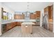 Modern kitchen with wood cabinets, stainless appliances, tile backsplash, and large island with quartz countertop at 933 Saint Andrews Ln, Louisville, CO 80027