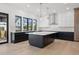 Spacious kitchen features a large center island, modern stainless hood, and white-and-black cabinetry at 933 Saint Andrews Ln, Louisville, CO 80027