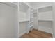 Bright walk-in closet features white shelves, ample storage space, and wood flooring at 933 Saint Andrews Ln, Louisville, CO 80027