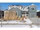 Two-story craftsman style home with gray siding, solar panels, and snowy landscaping at 4911 Colorado River Dr, Firestone, CO 80504