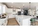Modern kitchen with white cabinets, large island, and views into dining area at 4911 Colorado River Dr, Firestone, CO 80504
