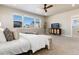 Main bedroom with large windows, carpet, and ceiling fan at 4911 Colorado River Dr, Firestone, CO 80504