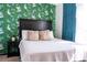 Comfortable bedroom with accent wallpaper, neutral bedding, and soft lighting for a relaxing ambiance at 19044 E 16Th Ave, Aurora, CO 80011