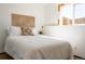 Bright bedroom featuring a decorative wooden headboard, stylish pillow, and sunny window at 19044 E 16Th Ave, Aurora, CO 80011