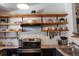 Well-organized kitchen featuring open wooden shelving, granite countertops, and modern appliances at 19044 E 16Th Ave, Aurora, CO 80011