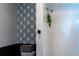 Clean, tiled shower area with modern fixtures and black and white geometric wallpaper detail at 19044 E 16Th Ave, Aurora, CO 80011