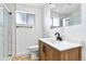 Bright bathroom featuring a new vanity, toilet, framed window and glass shower doors at 4556 S Pagosa Way, Aurora, CO 80015