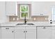 Updated kitchen featuring a stainless steel sink, sleek marble countertops and white cabinetry at 4556 S Pagosa Way, Aurora, CO 80015