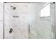 Close up of a modern shower with marble style tile, glass doors and bronze fixtures at 4556 S Pagosa Way, Aurora, CO 80015