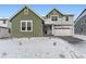 Charming two-story home with a green section, a lawn covered with snow, and an attached two car garage at 39877 Floyd St, Elizabeth, CO 80107
