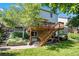 A backyard with stairs going to the wooden porch above and some foliage at 735 Poppy Pl, Highlands Ranch, CO 80129