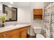 Bright bathroom with wooden vanity, medicine cabinet, and shower with patterned curtain at 735 Poppy Pl, Highlands Ranch, CO 80129