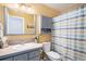 Bathroom with gray cabinets, a large mirror, and a colorful striped shower curtain at 735 Poppy Pl, Highlands Ranch, CO 80129