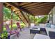 Cozy covered patio with a fire pit and comfortable seating beneath a wooden staircase at 735 Poppy Pl, Highlands Ranch, CO 80129