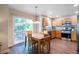 Eat-in kitchen features wood floors, stainless steel appliances, a breakfast table, and a sliding glass door to the deck at 735 Poppy Pl, Highlands Ranch, CO 80129