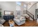Comfortable living room with a staircase and large windows, creating a bright and welcoming space at 735 Poppy Pl, Highlands Ranch, CO 80129