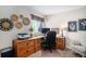 Bright home office featuring custom wooden desk, comfortable chair, decorative artwork, and window with natural light at 735 Poppy Pl, Highlands Ranch, CO 80129