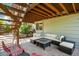 Under-deck patio with wicker seating, fire table, and access to lush backyard at 735 Poppy Pl, Highlands Ranch, CO 80129