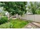 Lush backyard with a patio, dining set, landscaped garden, and privacy fence at 13025 Umatilla Ct, Denver, CO 80234