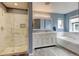 Bright bathroom features double vanity, soaker tub, and glass shower enclosure at 13025 Umatilla Ct, Denver, CO 80234