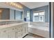 Bathroom features a soaking tub with tile surround, and double vanity at 13025 Umatilla Ct, Denver, CO 80234