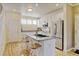 Bright kitchen features hardwood floors, stainless steel appliances, and a kitchen island with barstool seating at 13025 Umatilla Ct, Denver, CO 80234