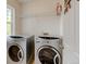 Laundry room with side-by-side washer and dryer, complemented by a wire shelf at 13025 Umatilla Ct, Denver, CO 80234