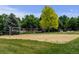 Outdoor sand volleyball court with a net surrounded by lush green grass and mature trees at 13025 Umatilla Ct, Denver, CO 80234