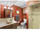 Bathroom featuring a stylish vessel sink, a tiled shower, and a warm, inviting color scheme at 7830 W Friend Pl, Littleton, CO 80128