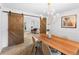 Charming dining room featuring a chandelier and barn doors leading to a sun-filled living space at 7830 W Friend Pl, Littleton, CO 80128